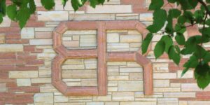 A brick wall has the letters BR picked out in red brick