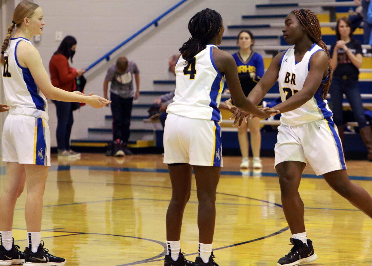 Three players slap hands in preparation for a game.