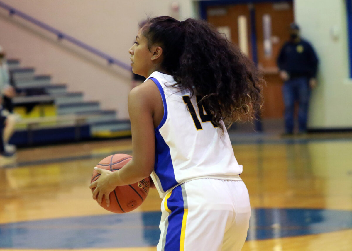 A girl holds a basketball.