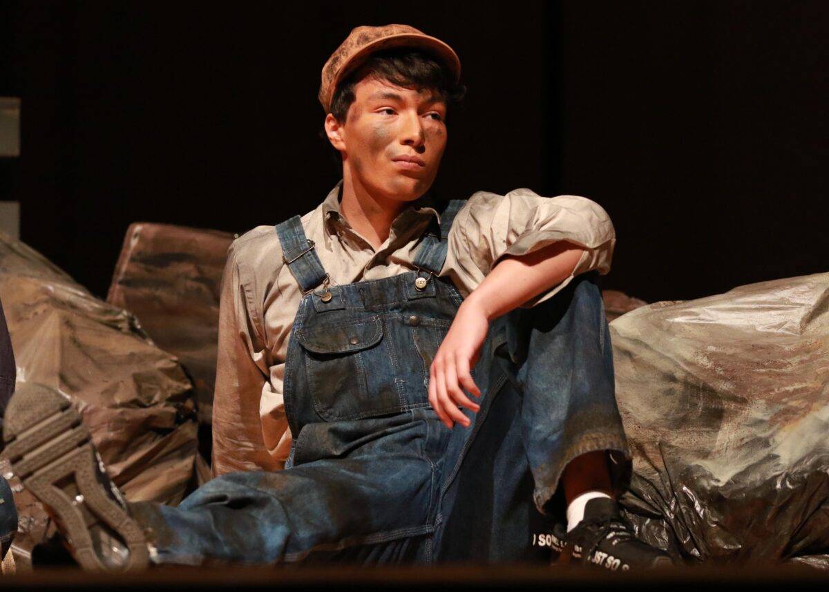A boy dressed as a miner acts in the play "Digging Up the Boys."
