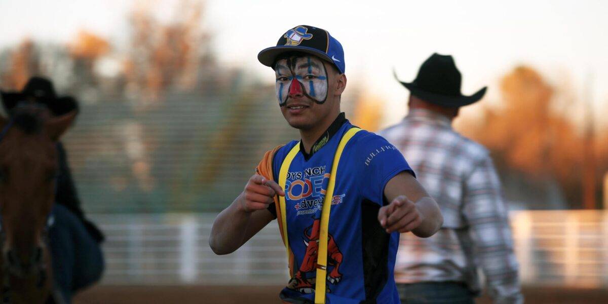 A boy with a painted face wears a Boys Ranch T-shirt and yellow suspenders.
