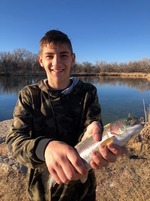 A boy holds his first trout.