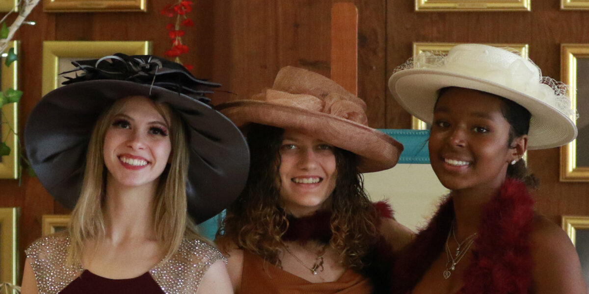 three girls in fancy hats