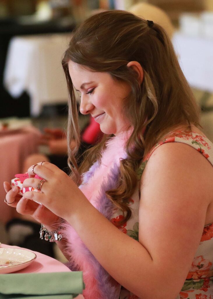 a girl opens a package with a happy smile.