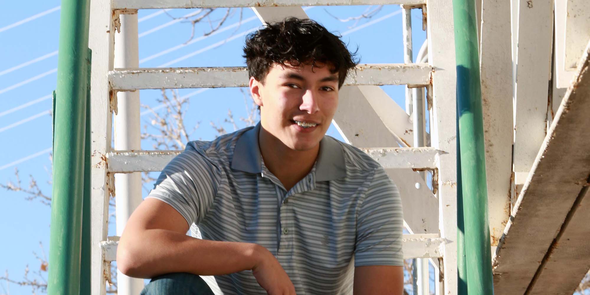 A boy sits on an outdoor set of steps.