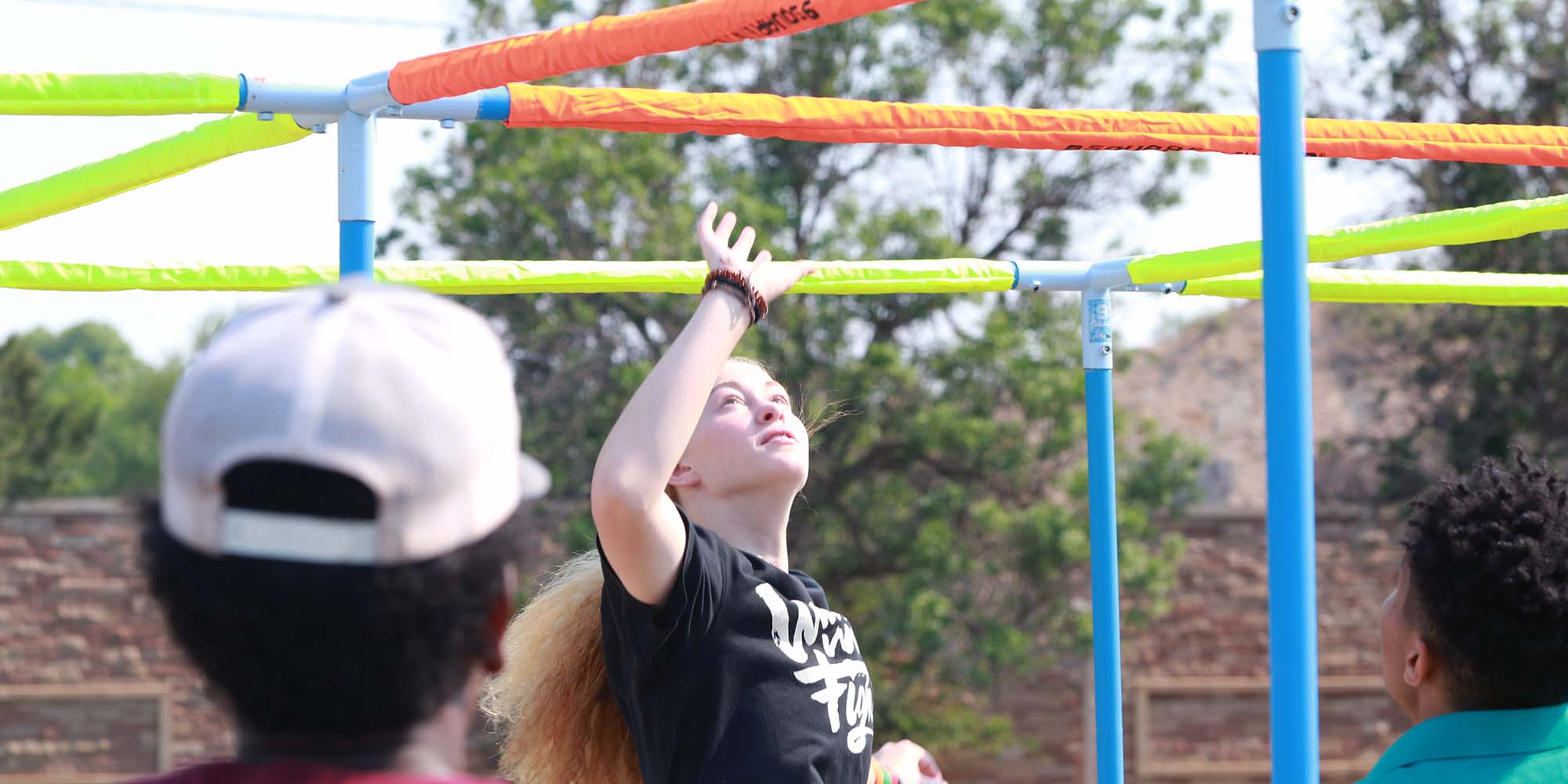 A girl is ready to spike a ball in nine square in the air.