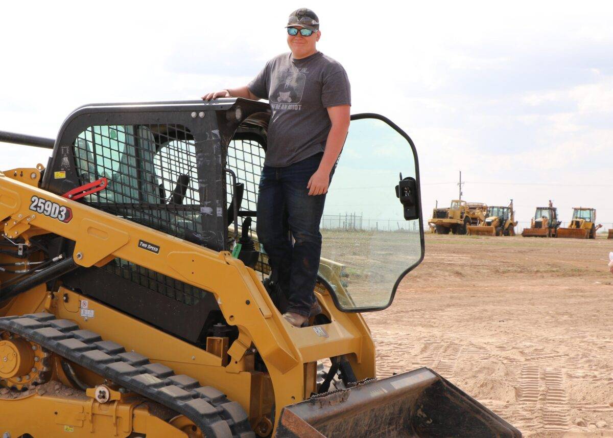A boy learns to operate a skid-loader in FFA class