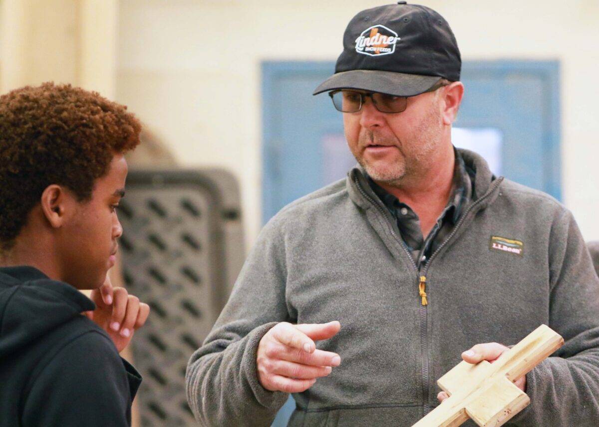 A teacher shows an FFA student some changes he can make to a project.