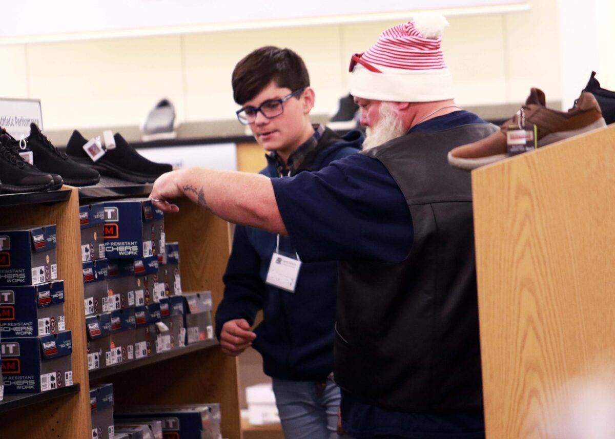 A man and a boy consider shoe choices.