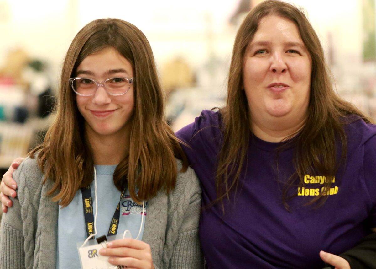 A woman and a girl shop for clothing.