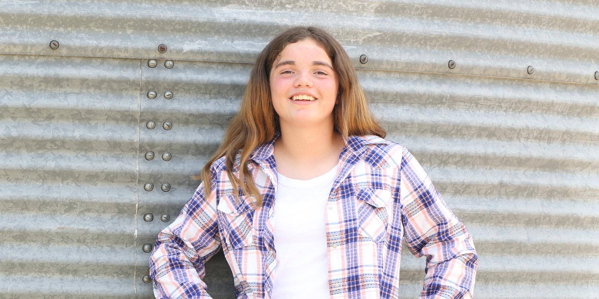 Alina stands in front of a grain bin