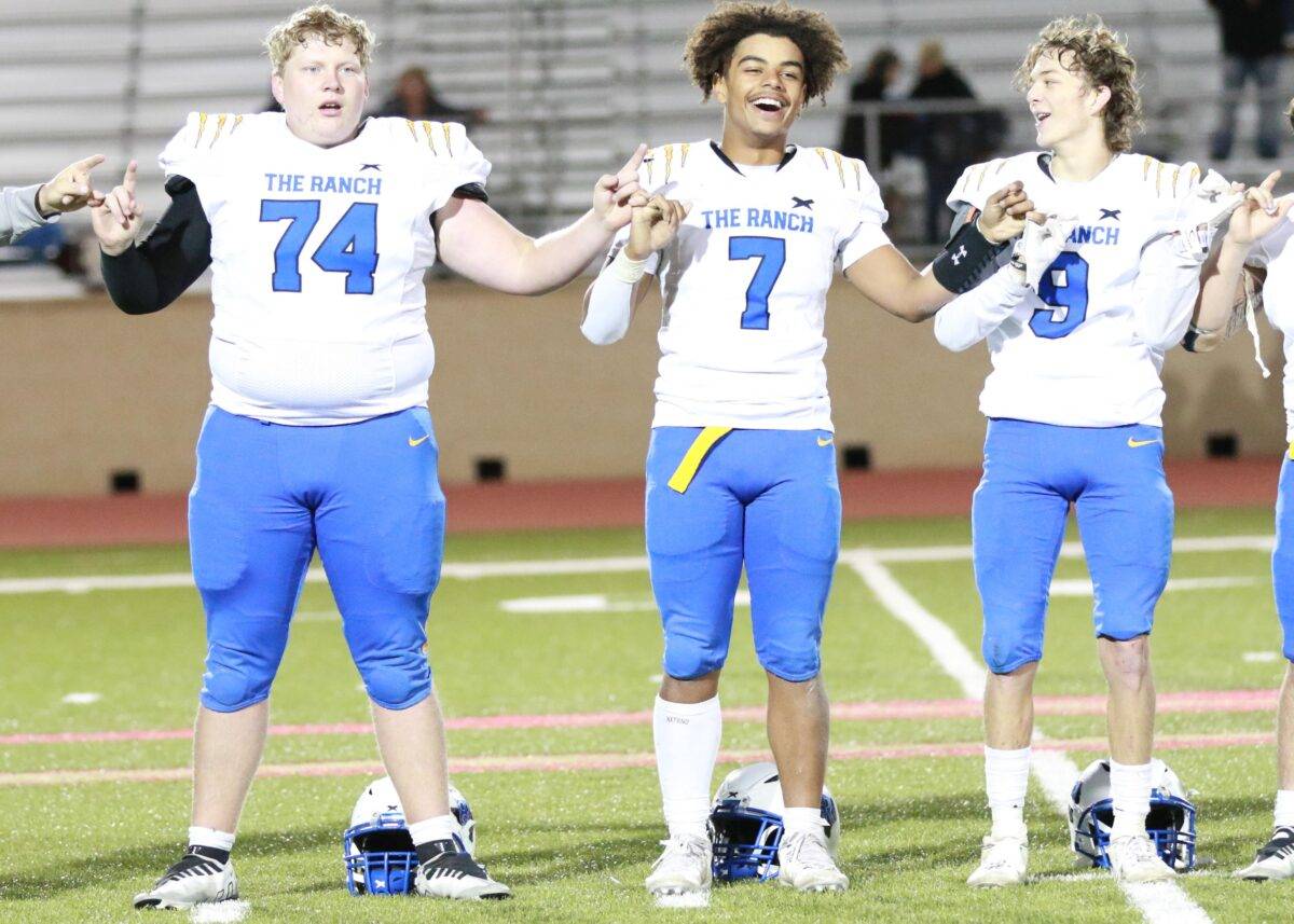 Three football players sing the school song