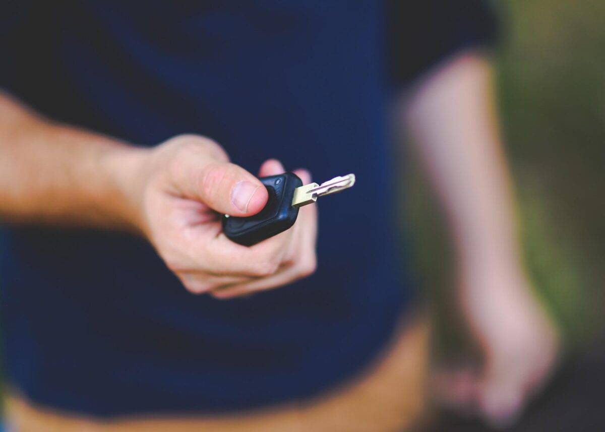 a hand holds a car key
