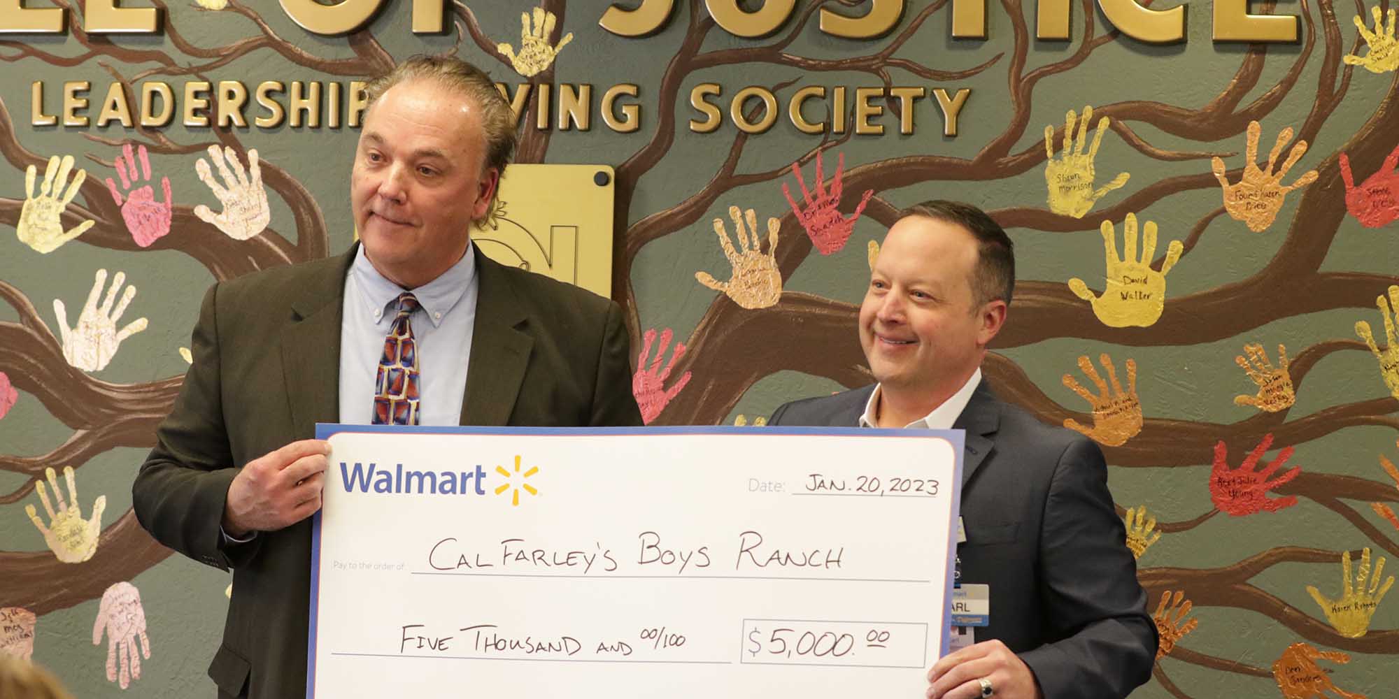 Cal Farley's Boys Ranch President and CEO Richard Nedelkoff receives a check from Carl Carruthers of Walmart.