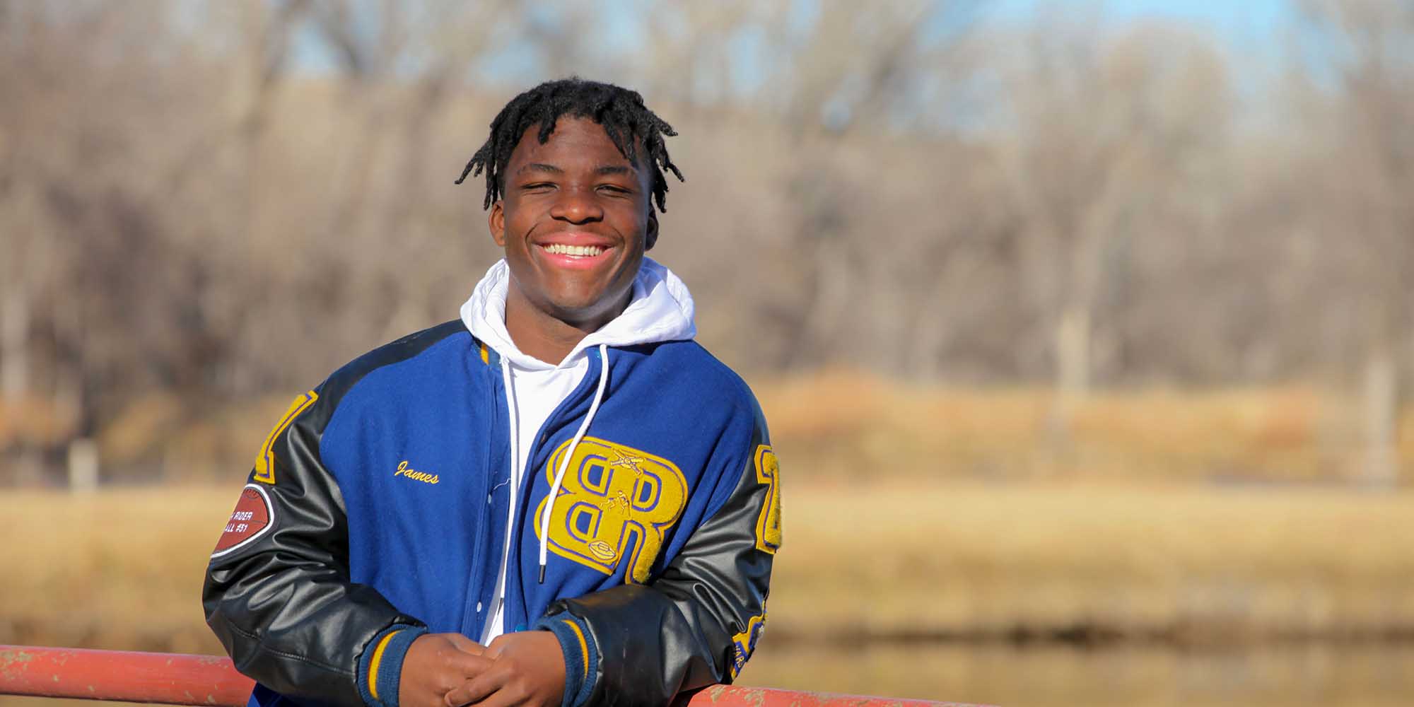 Jaay smiles beside a lake at Boys Ranch.